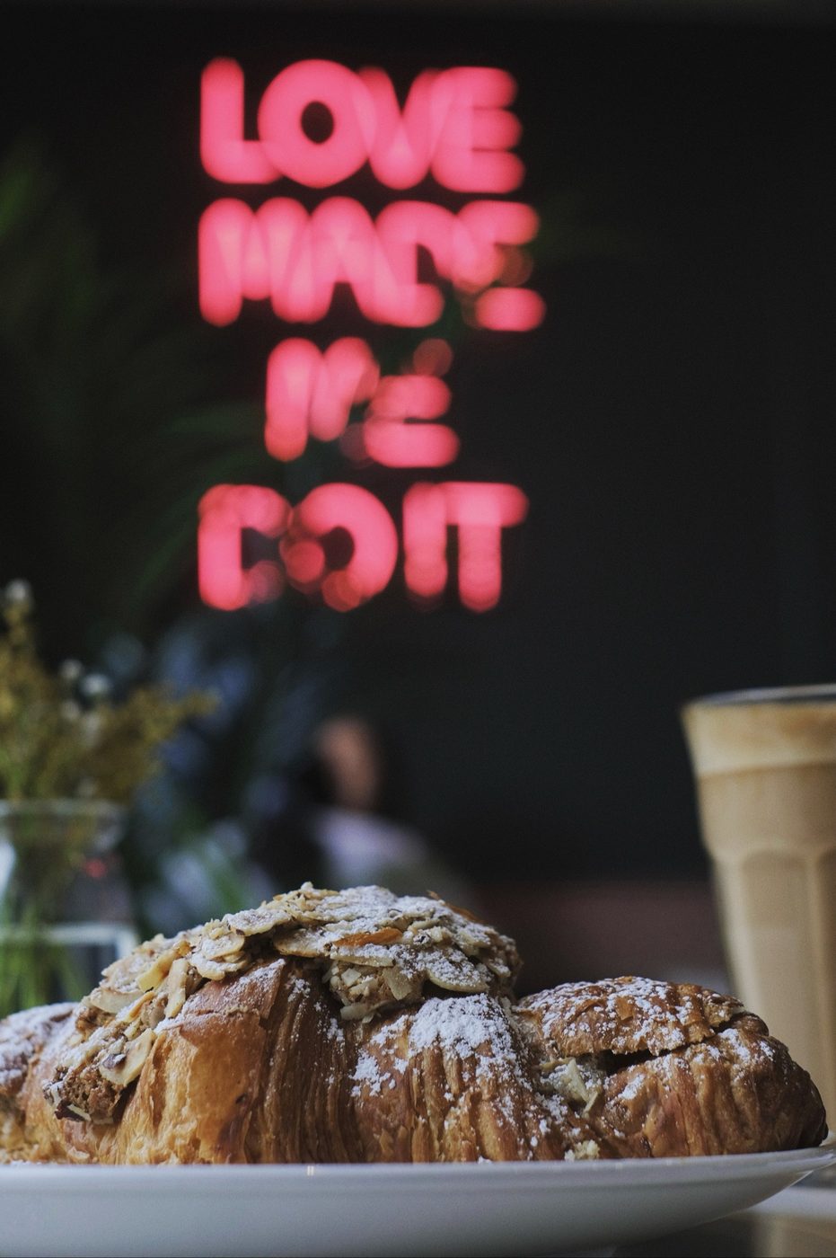 Croissant and latte with neon sign — bold food photography