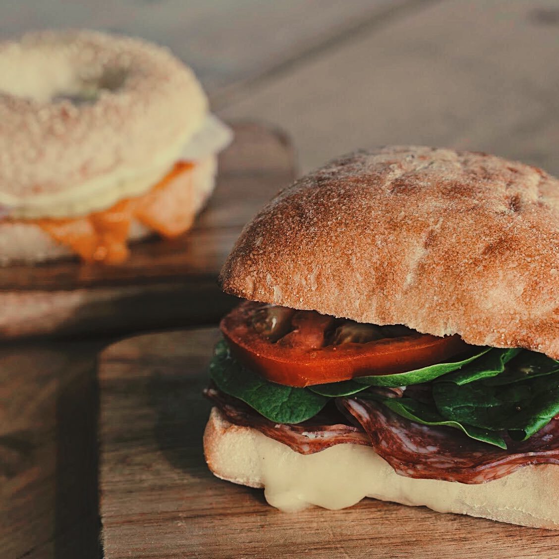 Stacked breakfast sandwich with bacon and greens