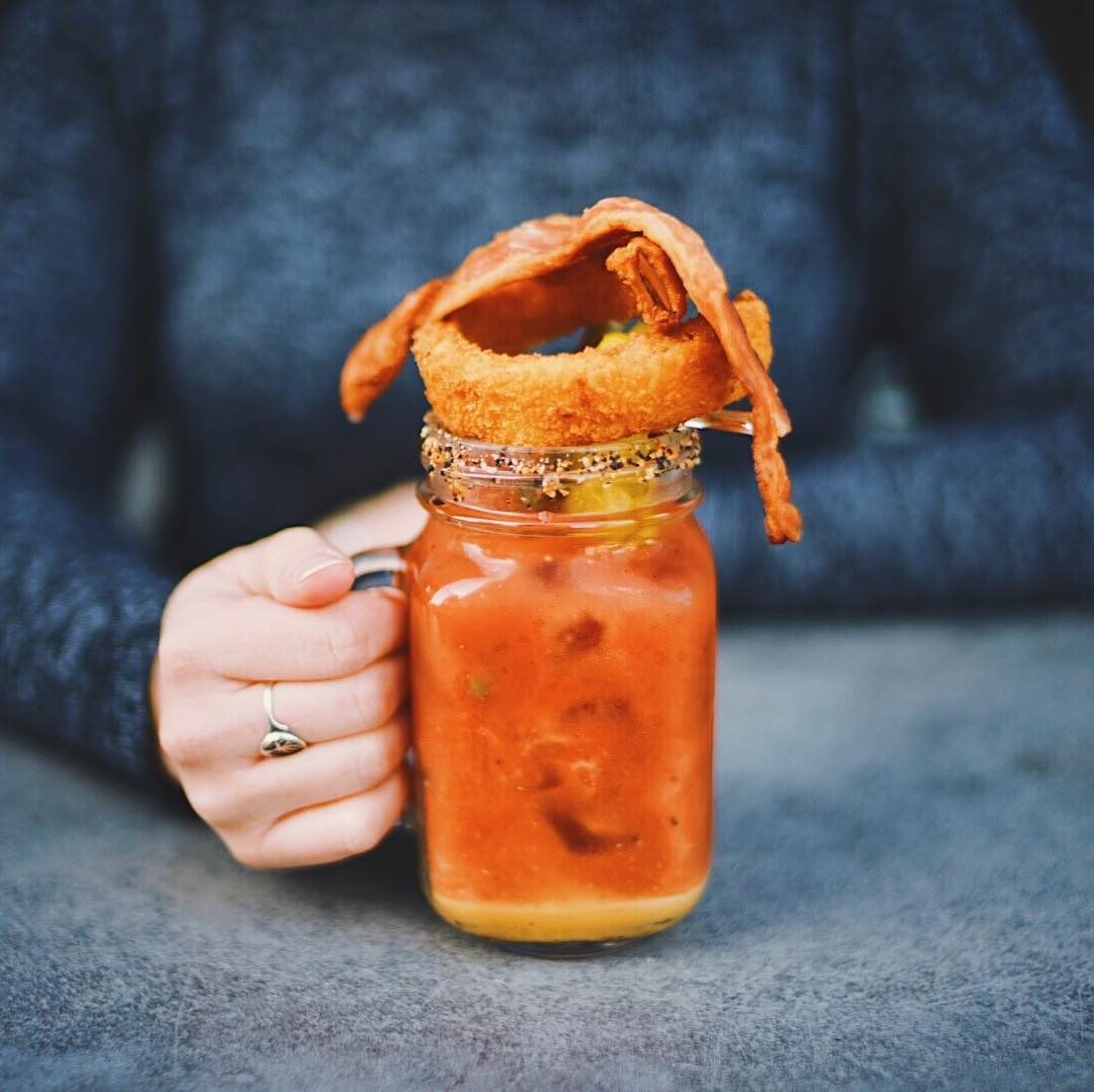 Hand-held bloody mary in a mason jar